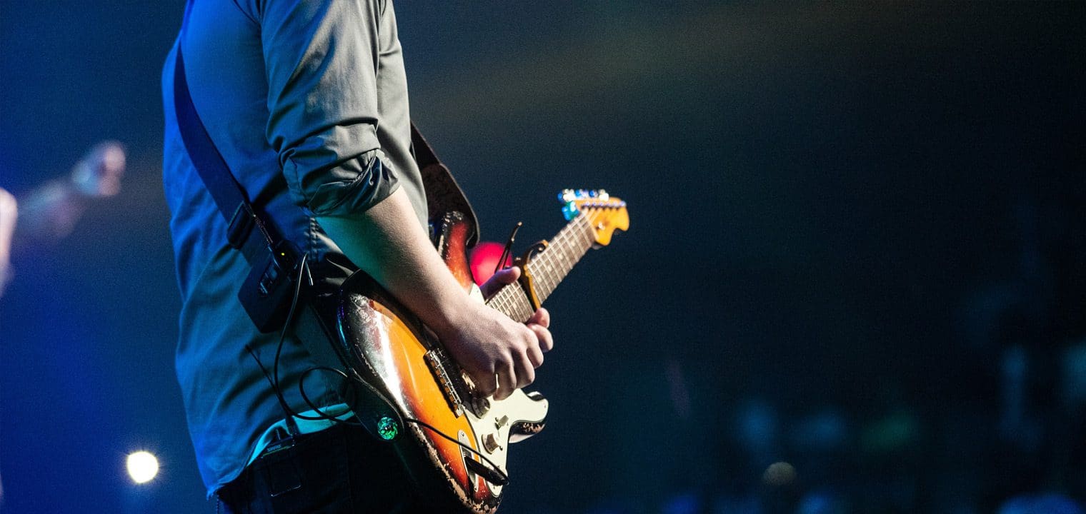 A man playing an electric guitar at a concert.